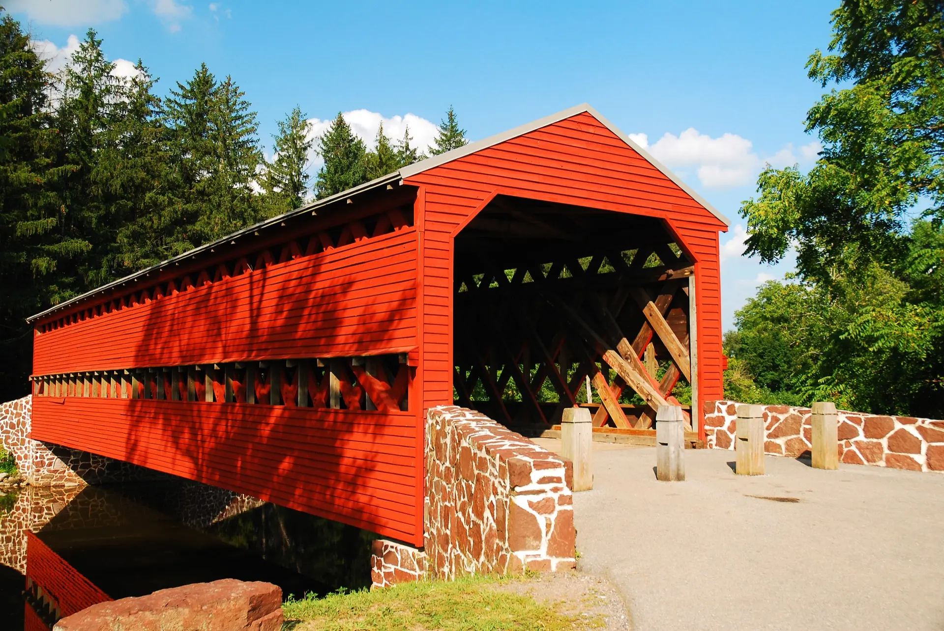 A red covered bridge surrounded by spring trees